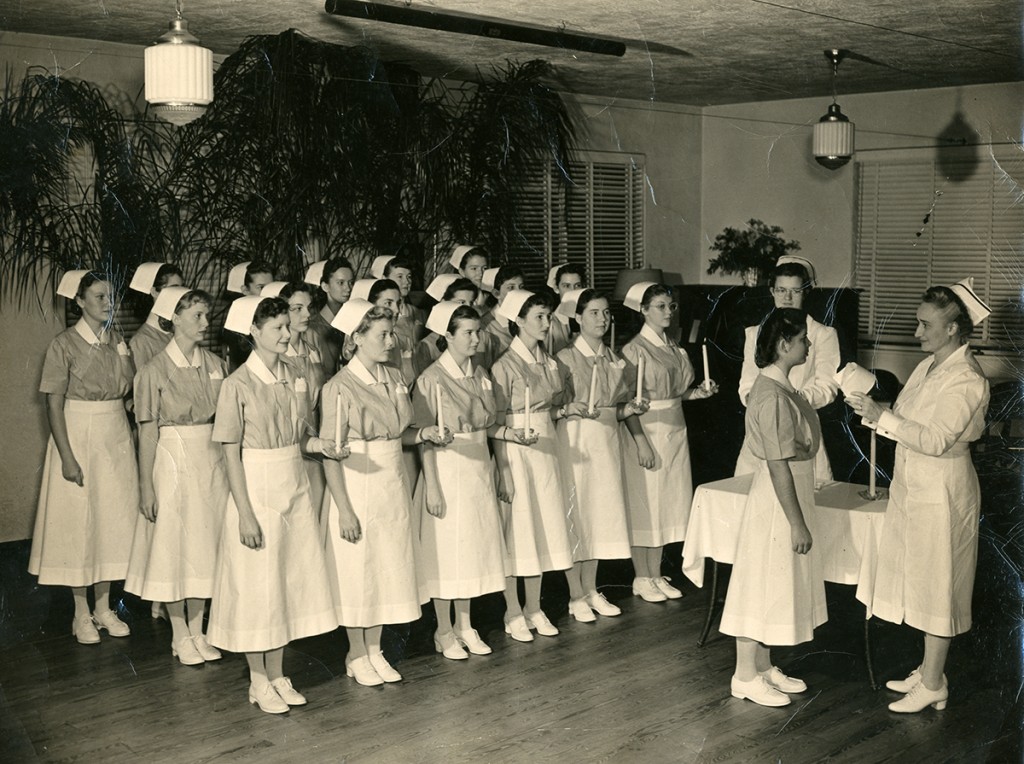  Nurses receive their caps during a graduation ceremony.